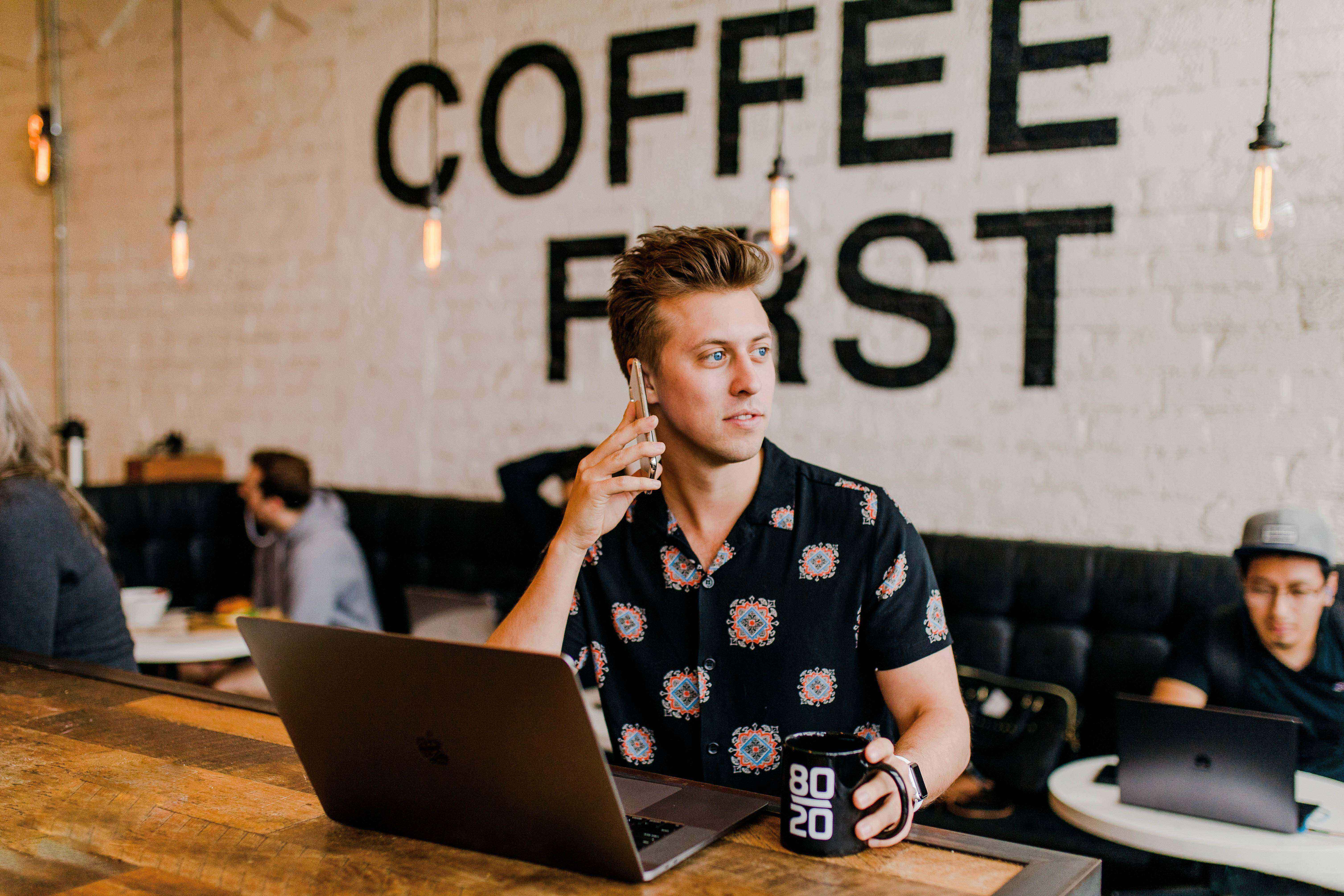 A person holding a phone at a coffee shop